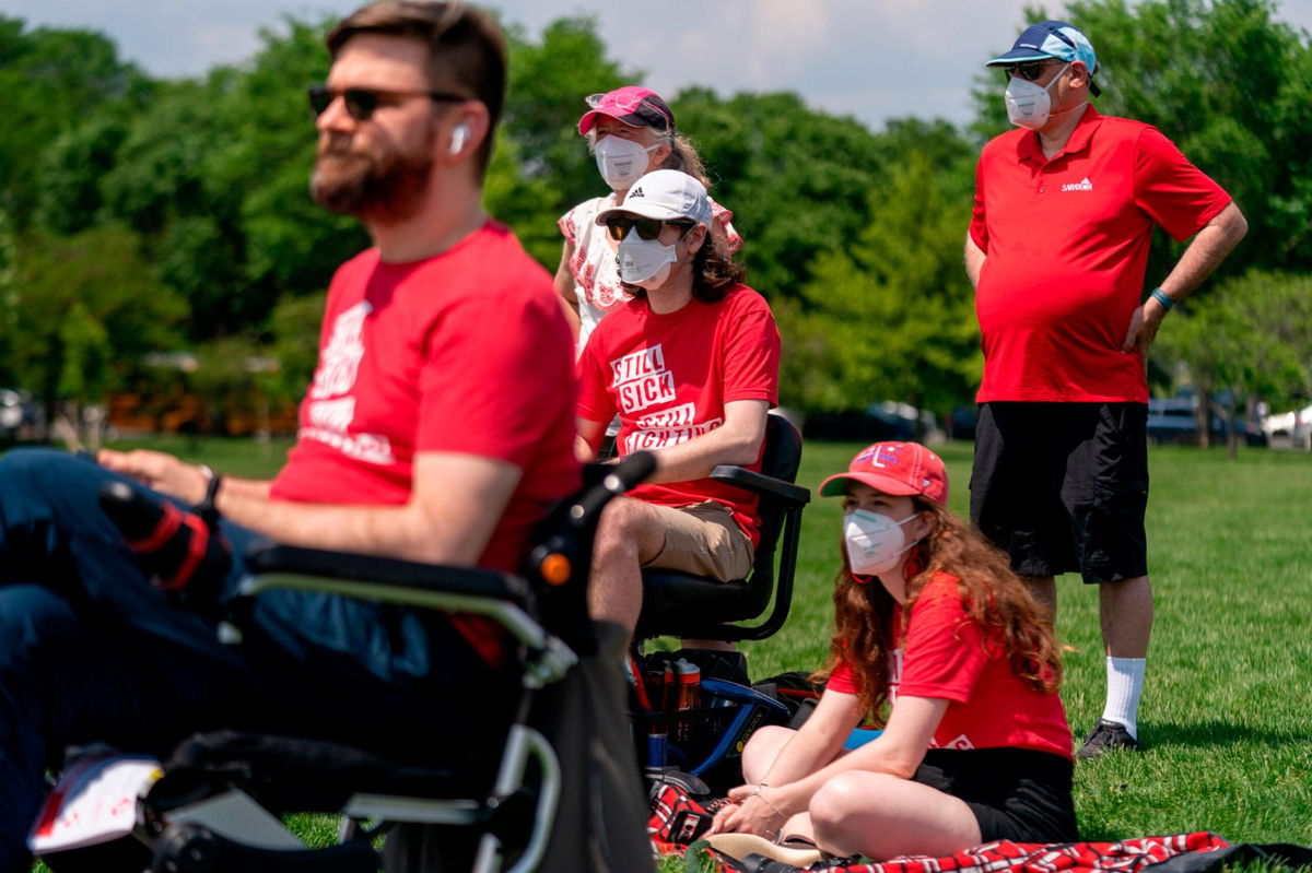 <i>Andrew Harnik/AP</i><br/>Advocates for people suffering from long COVID-19 and chronic fatigue syndrome install 300 cots in front of the Washington Monument in Washington