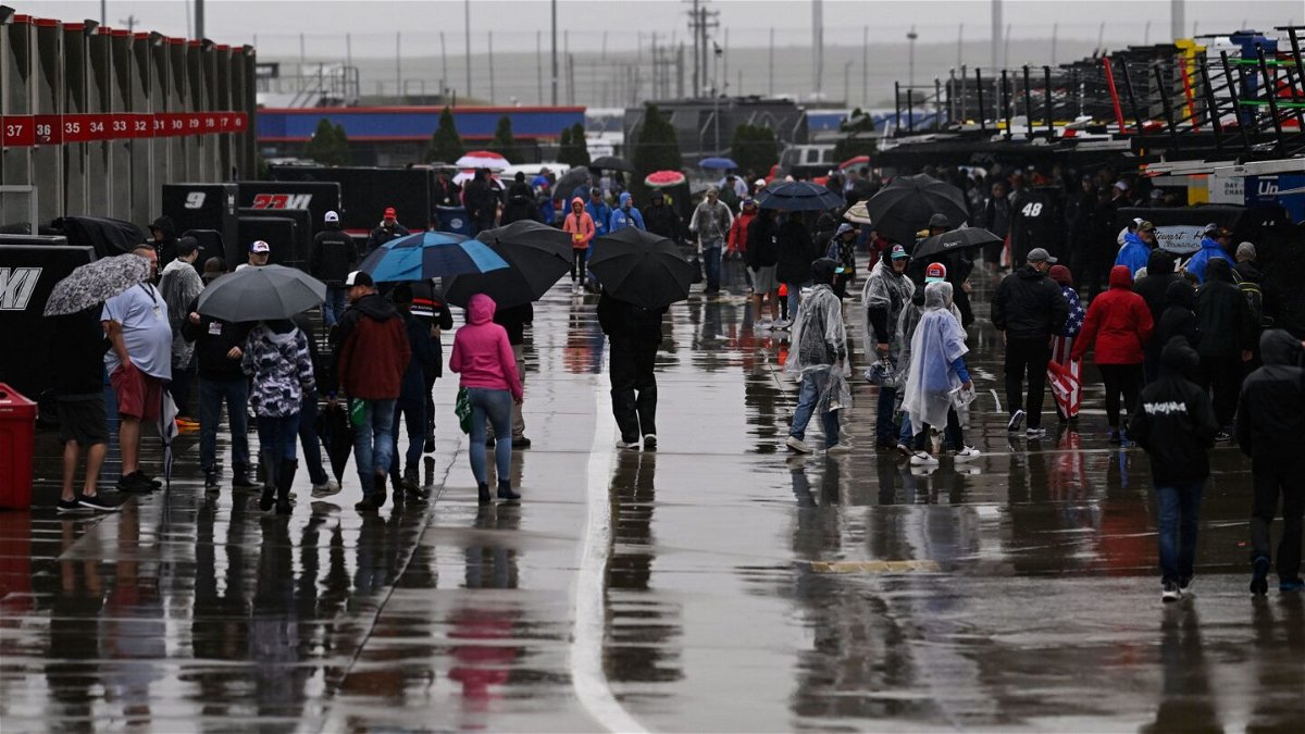 <i>Matt Kelley/AP</i><br/>Race fans walk through the garage area while rain causes a delay to a NASCAR Cup Series race at Charlotte Motor Speedway on Sunday.