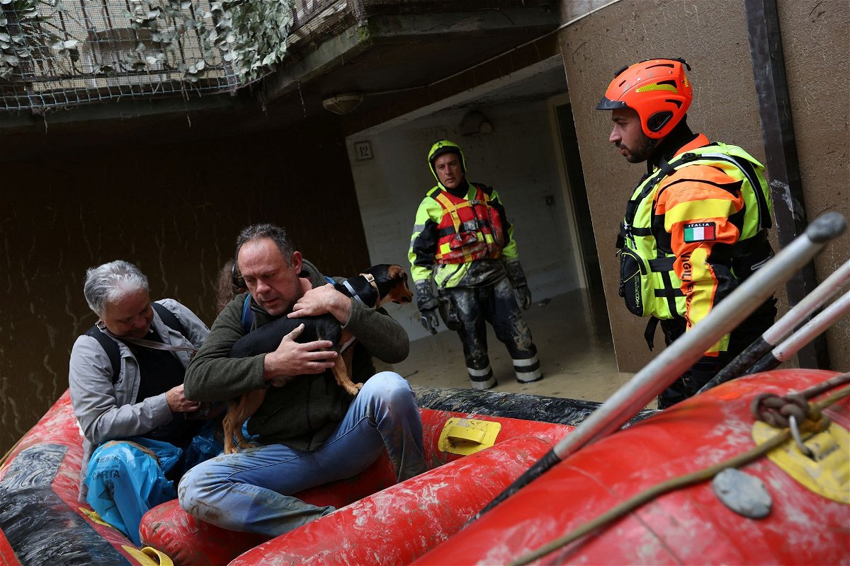 <i>Claudia Greco/Reuters</i><br/>Rescue workers evacuate people and a dog from a flooded house in Faenza on Friday.