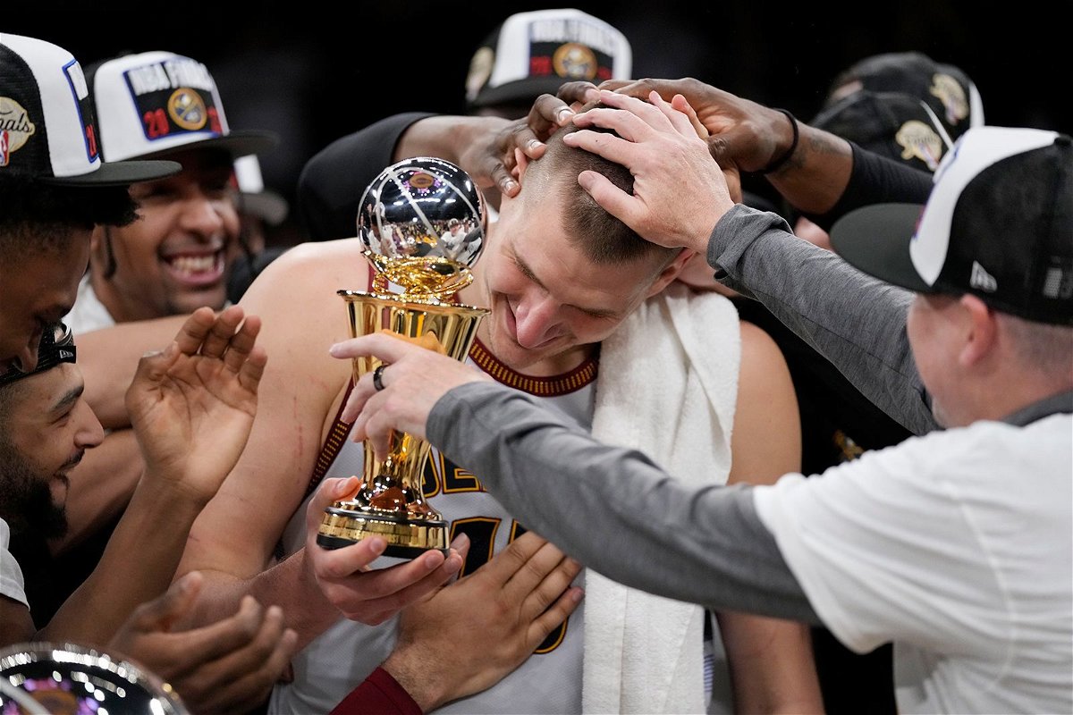 <i>Ashley Landis/AP</i><br/>Denver Nuggets center Nikola Jokic surrounded by teammates after accepting the series MVP trophy after Game 4 of the NBA basketball Western Conference Final series on Monday.