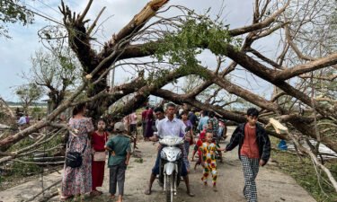 Residents walk past fallen trees in Kyauktaw in Myanmar's Rakhine state on May 15