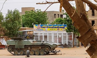 Sudanese Army soldiers rest near a tank at a checkpoint in Khartoum on April 30