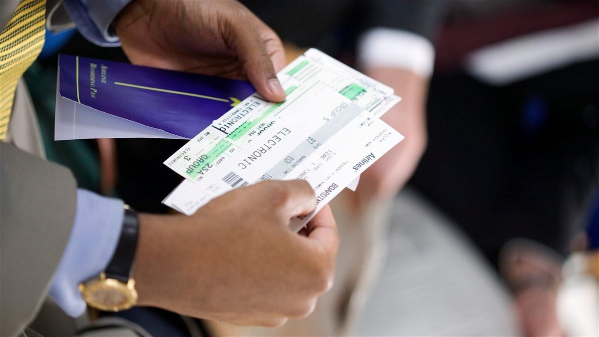 <i>Creatas/Creatas RF/Getty Images</i><br/>A man holds a paper boarding pass