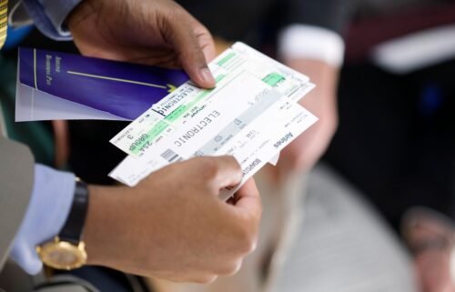A man holds a paper boarding pass