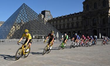 Jonas Vingegaard in action with riders passing the Louvre museum in Paris during the 2022 Tour de France.