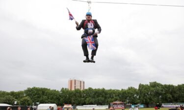 Boris Johnson gets stuck on a zip-line in Victoria Park in London where the 2012 Olympic Games were being shown on a big screen on August 1