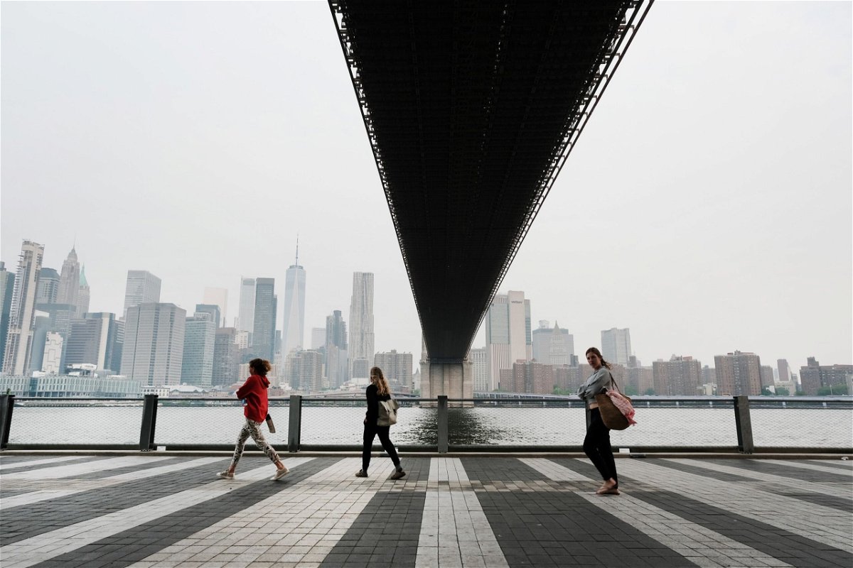 <i>Spencer Platt/Getty Images</i><br/>People walk through a Brooklyn Park in New York City on Tuesday morning. Air pollution levels were unhealthy for sensitive groups due to smoke from Canada's wildfires.