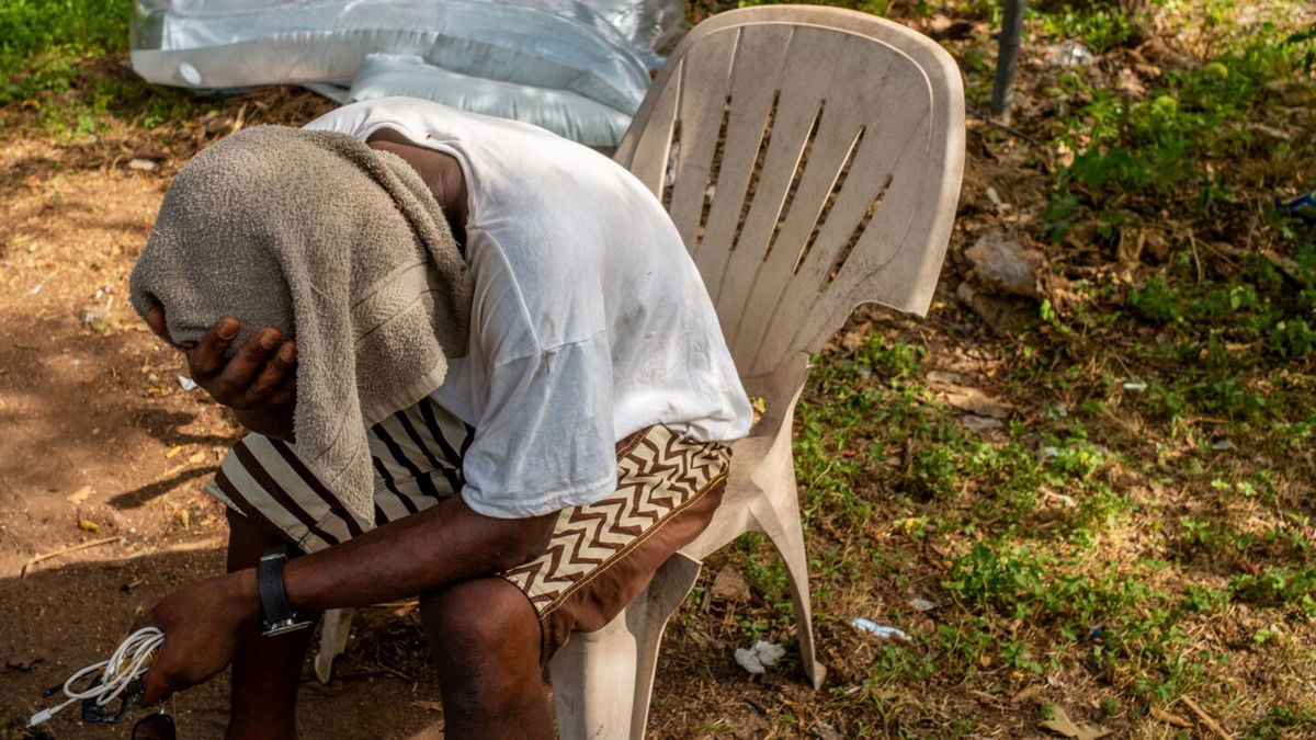 <i>Brandon Bell/Getty Images</i><br/>A man sits with a towel over his head in the shade on June 19 in Austin