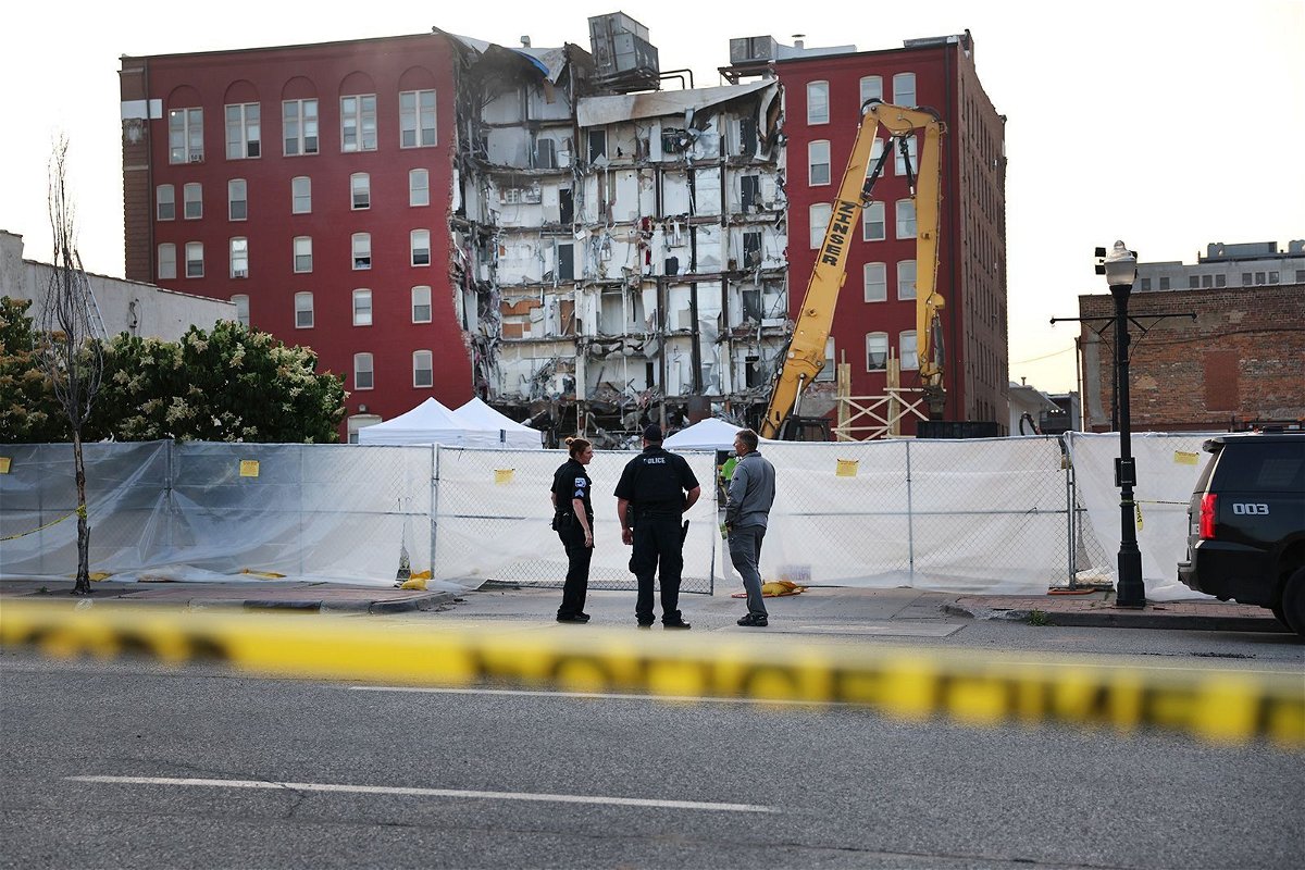 <i>Scott Olson/Getty Images</i><br/>Officials stand near a six-story apartment building after a section of it collapsed in Davenport