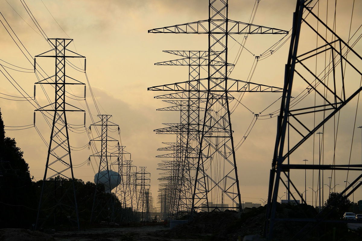 <i>David J. Phillip/AP</i><br/>The sun rises over power lines in Houston on June 27. Scorching temperatures have taxed the Texas power grid.