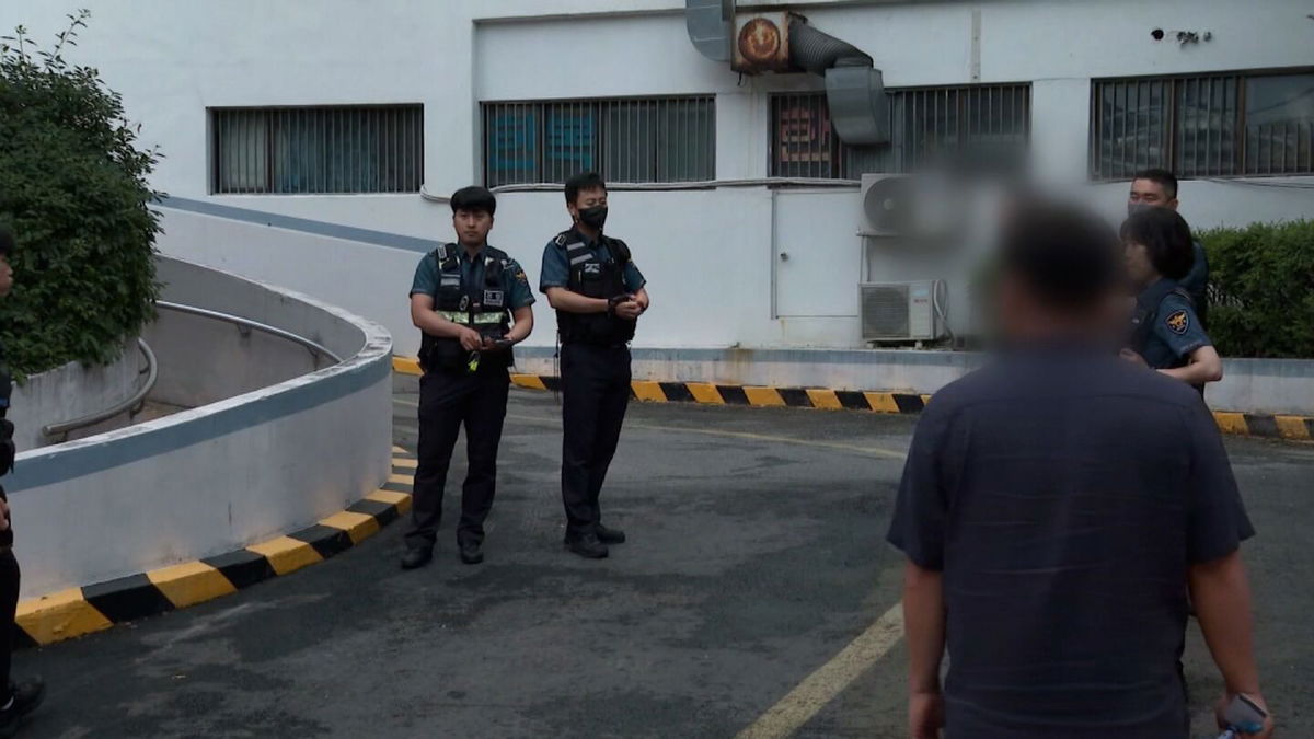 <i>jTBC</i><br/>Police officers outside a woman's residence in Suwon