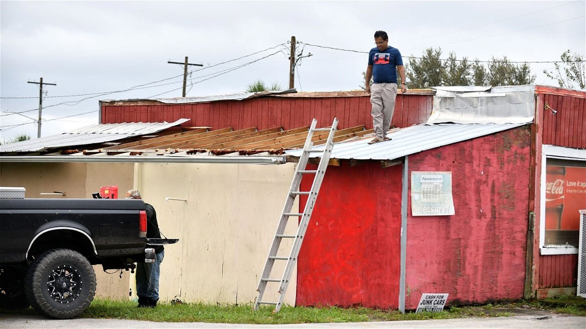 <i>Gerardo Mora/Getty Images</i><br/>Talukder Mahtab surveys the roof of his business after it was hit by the winds and rain from Hurricane Ian on September 29