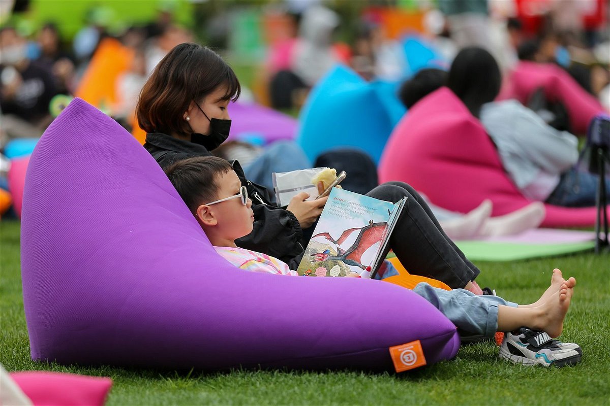 <i>Wang Yiliang/Xinhua/Getty Images</i><br/>A child reads a book at Seoul Plaza in Seoul