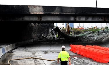 Workers inspect and clear debris from a section of the bridge that collapsed on Interstate 95 after an oil tanker explosion.