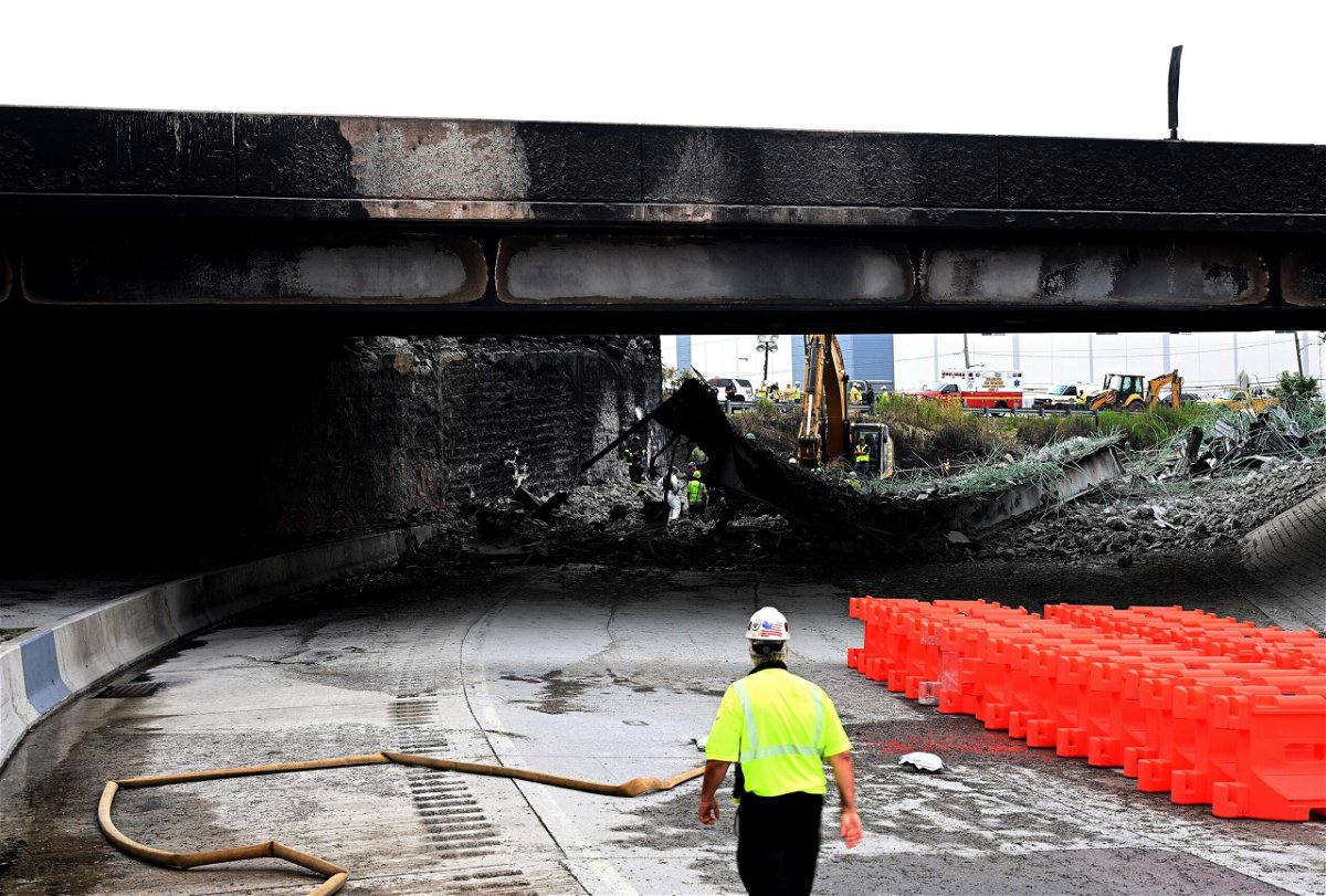 <i>Mark Makela/Getty Images</i><br/>Workers inspect and clear debris from a section of the bridge that collapsed on Interstate 95 after an oil tanker explosion.