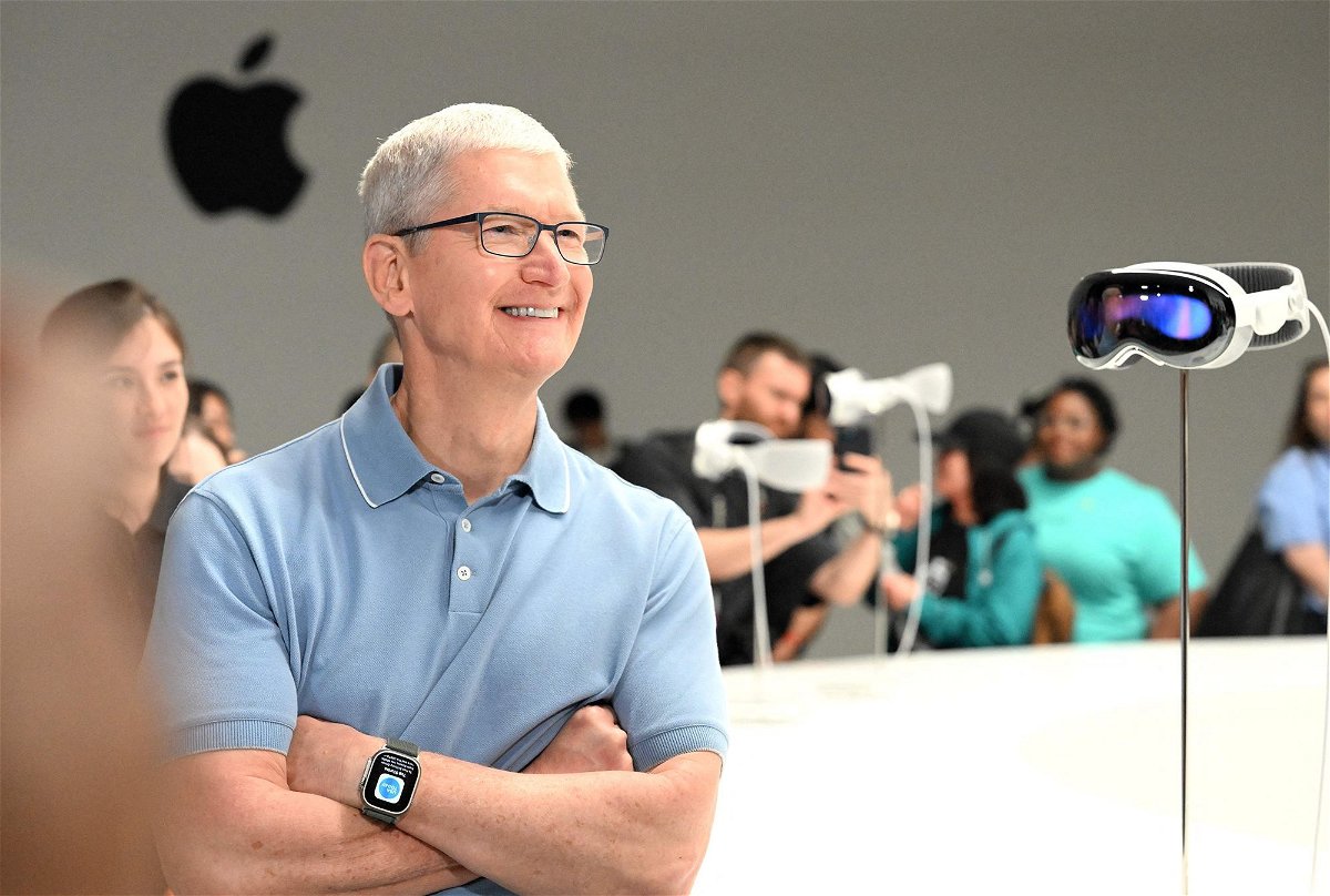 Apple CEO Tim Cook speaks with members of the media next to Apple's new Vision Pro virtual reality headset