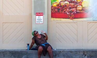 A woman fans herself outside a grocery store in New Orleans on June 28.