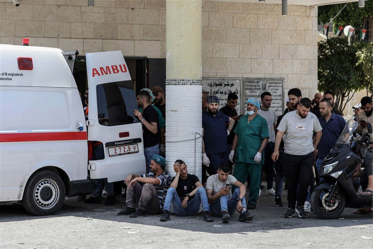 Palestinians wait outside a hospital while paramedics transport injured people during a large-scale Israeli military operation in the West Bank town of Jenin. At least eight Palestinians were killed