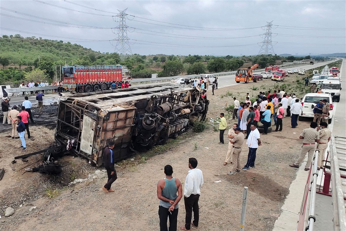 People gather around the wreckage of a bus that caught fire along the Samruddhi Mahamarg expressway near Sindkhed Raja in the Buldhana district of Maharashtra state