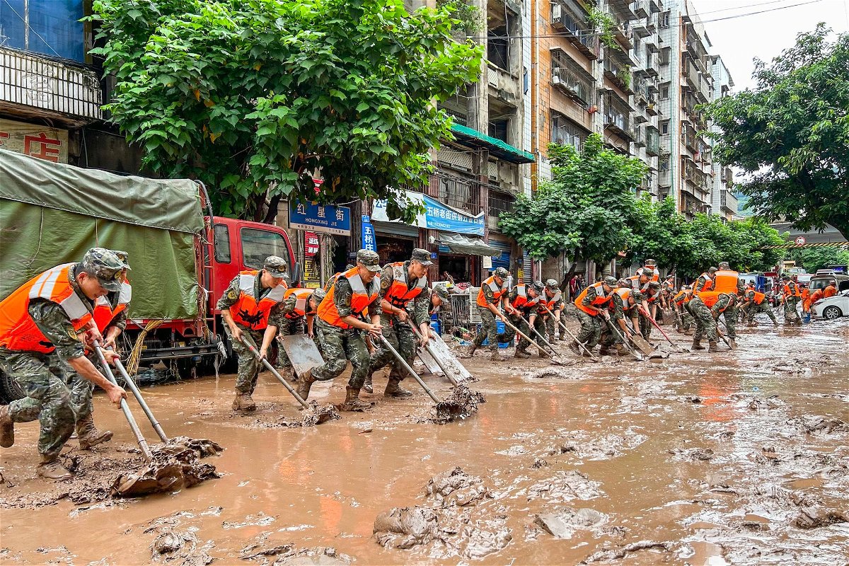 <i>Zou Yi/VCG/Getty Images</i><br/>Police clean up silt in Chongqing