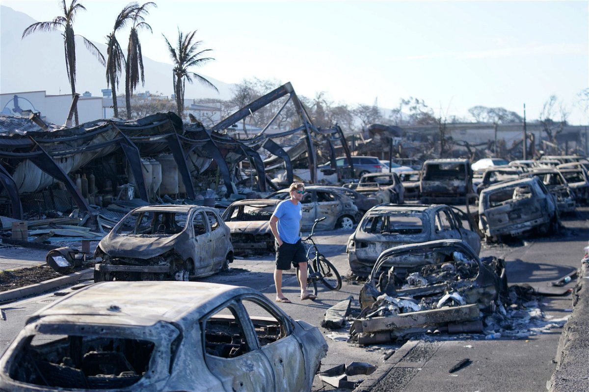 <i>Rick Bowmer/AP</i><br/>A man walks through wildfire wreckage on August 11 in Lahaina