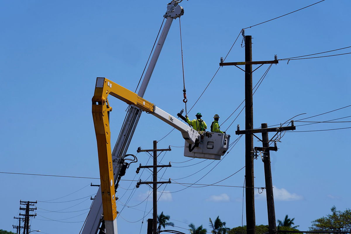 <i>Rick Bowmer/AP</i><br/>Linemen work on poles in Lahaina