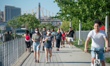 People walk in Gantry Plaza State Park in New York City.