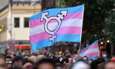 A person holds a transgender pride flag as people gather outside the Stonewall Inn in New York in June 2019. A study found that transgender and nonbinary patients have no regrets about top surgery.