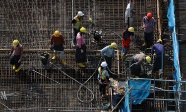 Migrant workers sit in the back of a lorry in Singapore on May 15