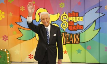 American game show host Bob Barker points to himself on a nearby television screen as his wife Dorothy Jo Barker (1924 - 1981) looks on and laughs