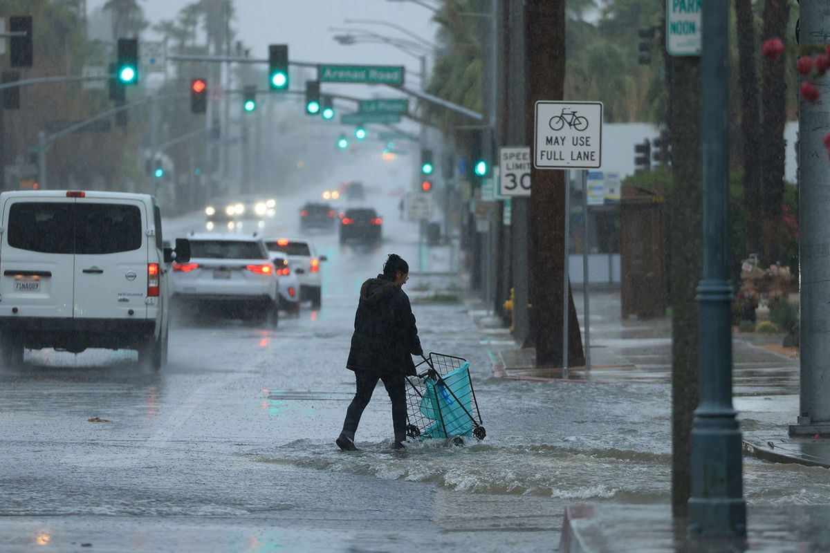 <i>David Swanson/AFP/Getty Images</i><br/>A person pushes a cart on a flooded street near Palm Springs