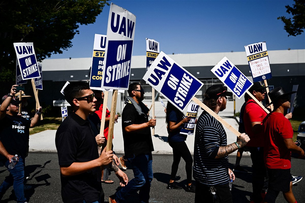 <i>Patrick T. Fallon/AFP/Getty Images</i><br/>Labor supporters and members of the United Auto Workers union (UAW) Local 230 march along a picket line during a strike outside of the Stellantis Chrysler Los Angeles Parts Distribution Center in Ontario