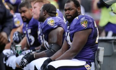 Baltimore Ravens offensive tackle Michael Oher sits on the beach during the first half of an NFL football game against the Buffalo Bills in Baltimore