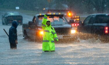 A person carries sandbags through water as heavy rain cause streets to flood in Hoboken