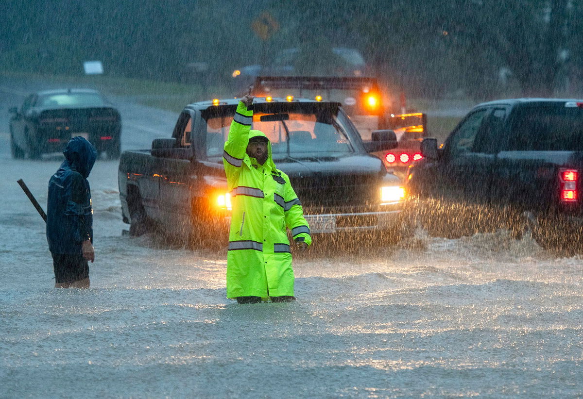 <i>Stefan Jeremiah/AP</i><br/>A person carries sandbags through water as heavy rain cause streets to flood in Hoboken