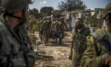 Israeli forces extract dead bodies of residents from a destroyed house in the Kfar Aza community.