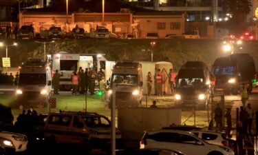 Israeli security forces stand next to ambulances waiting outside the helipad of Tel Aviv's Schneider medical center on November 24