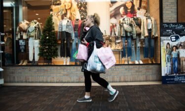 A shopper carries bags at the Polaris Fashion Place mall on Black Friday in Columbus