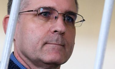 Paul Whelan stands inside a defendants' cage during a hearing at a court in Moscow on August 23