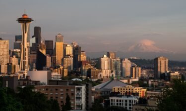 The Seattle skyline at sunset with Mount Rainier in the background. Amtrak runs multiple trains between Seattle and Portland.