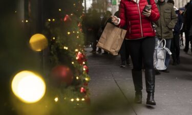 A woman carrying a shopping bag passes Macy's department store in Herald Square