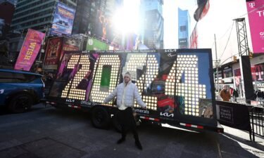 People pose in front of the 2024 New Year's Eve numerals after the illumination ceremony in Times Square on December 20.