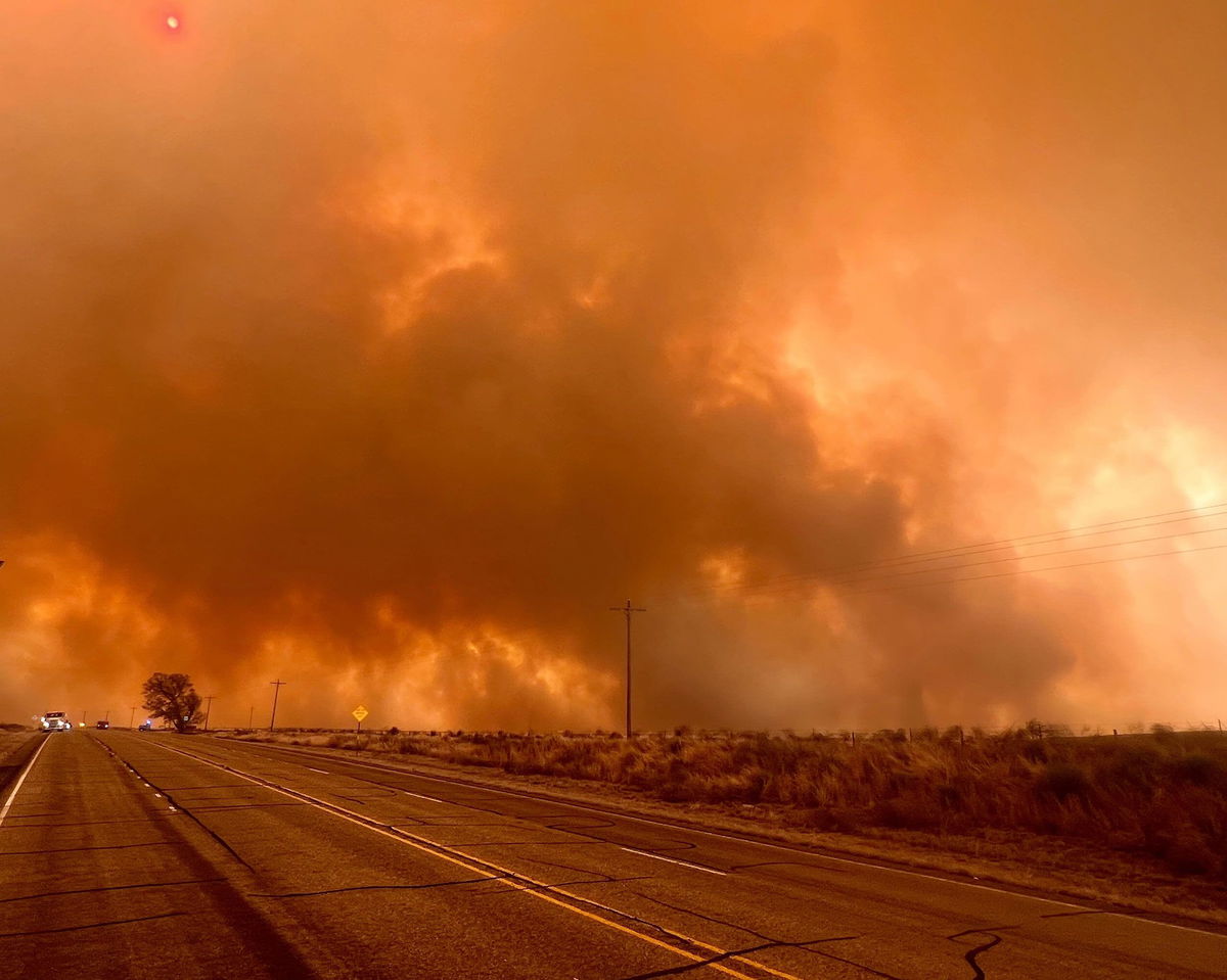 <i>Courtesy Miguel Lira/Booker Grocery Cafe & Catering via CNN Newsource</i><br/>A wildfire burns northwest of Canadian