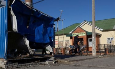 A man rides a bicycle near a damaged market pavilion hit by recent shelling in the town of Shebekino in the Belgorod region of Russia on March 11.