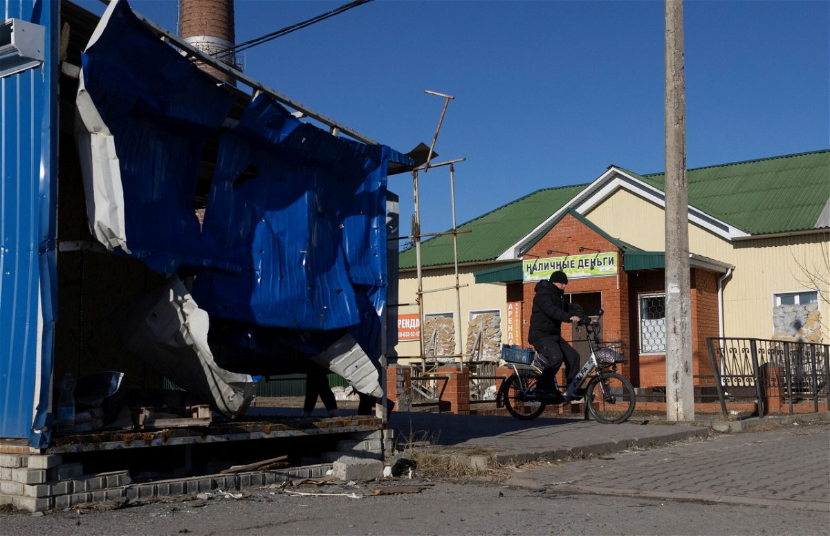 <i>Maxim Shemetov/Reuters via CNN Newsource</i><br/>A man rides a bicycle near a damaged market pavilion hit by recent shelling in the town of Shebekino in the Belgorod region of Russia on March 11.