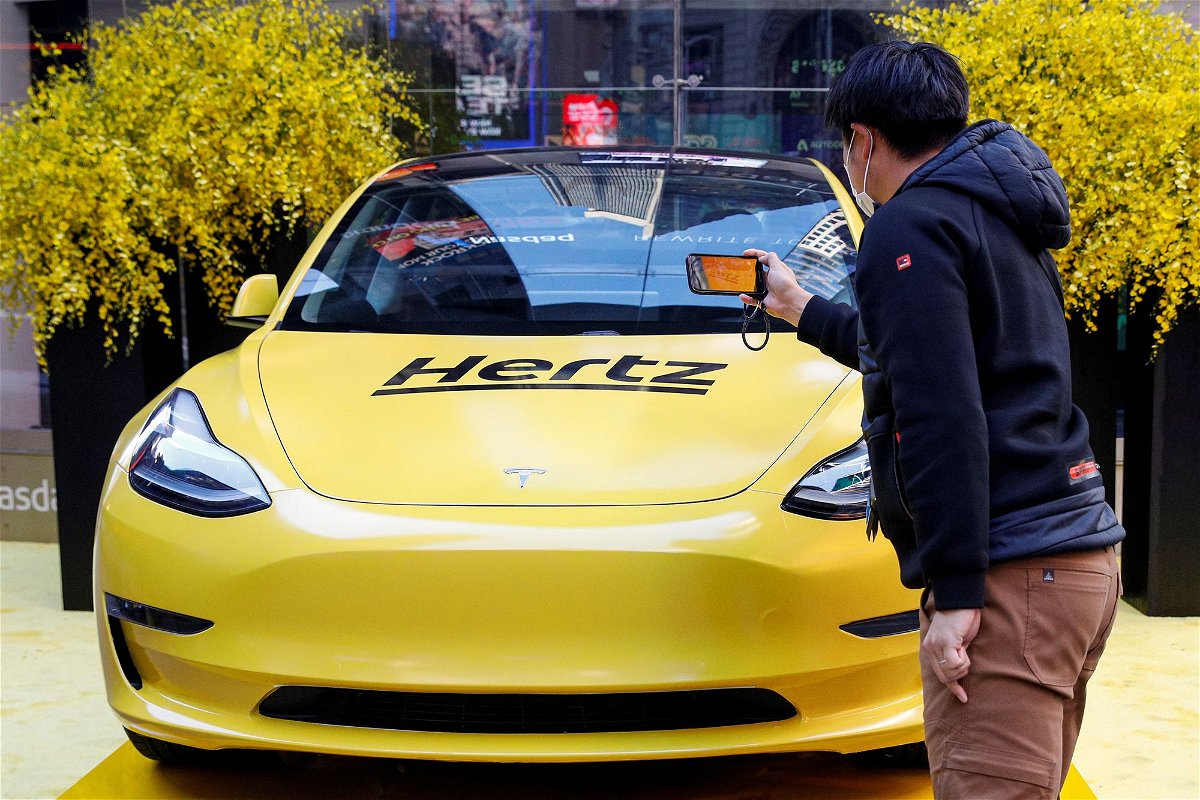 <i>Brendan McDermid/Reuters via CNN Newsource</i><br/>A man photographs a Hertz Tesla electric vehicle displayed during the Hertz Corporation IPO at the Nasdaq Market site in Times Square in New York City.