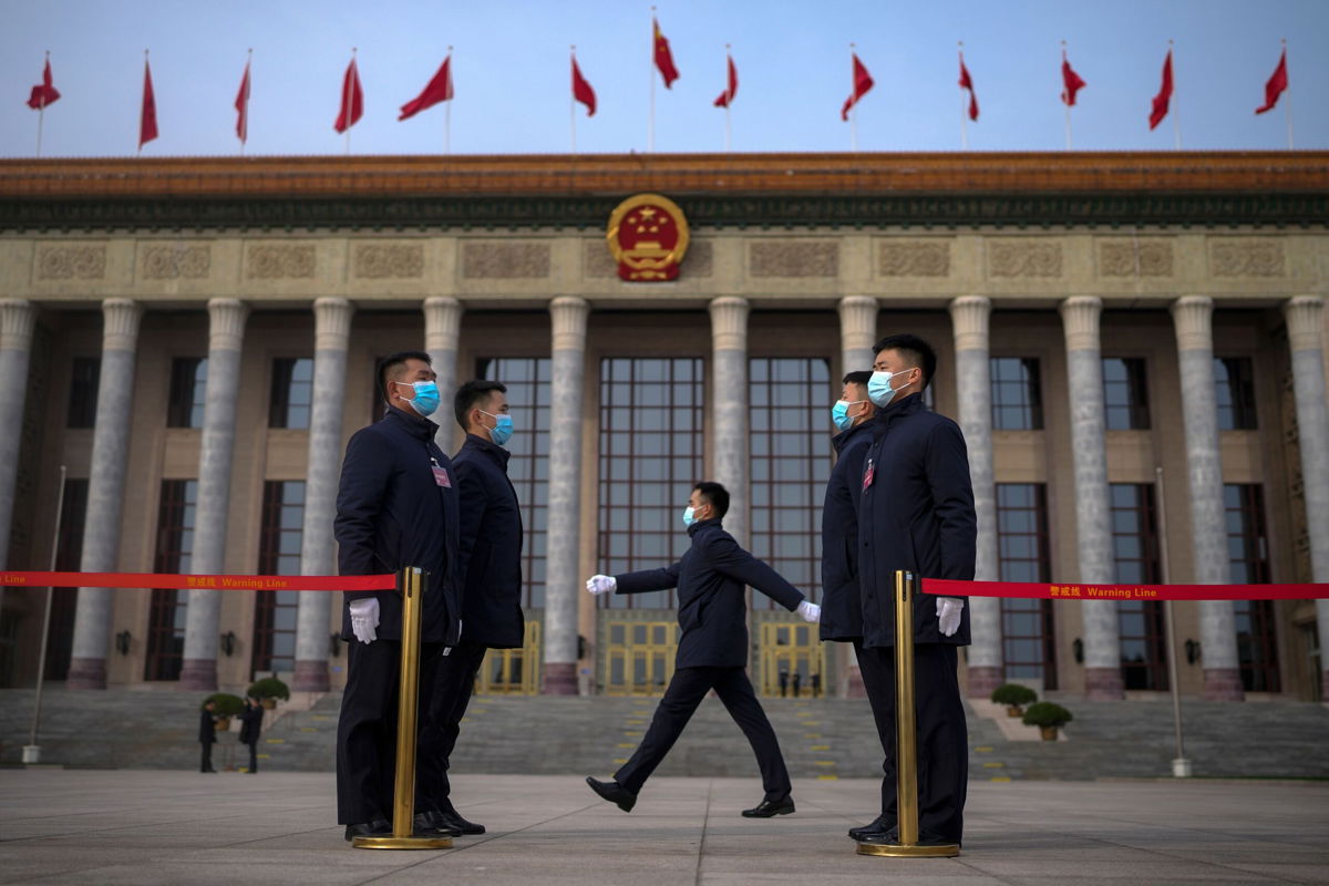 <i>Andy Wong/AP via CNN Newsource</i><br/>Soldiers dressed as ushers stand guard outside the Great Hall of the People ahead of the opening of the National People's Congress (NPC) in Beijing.
