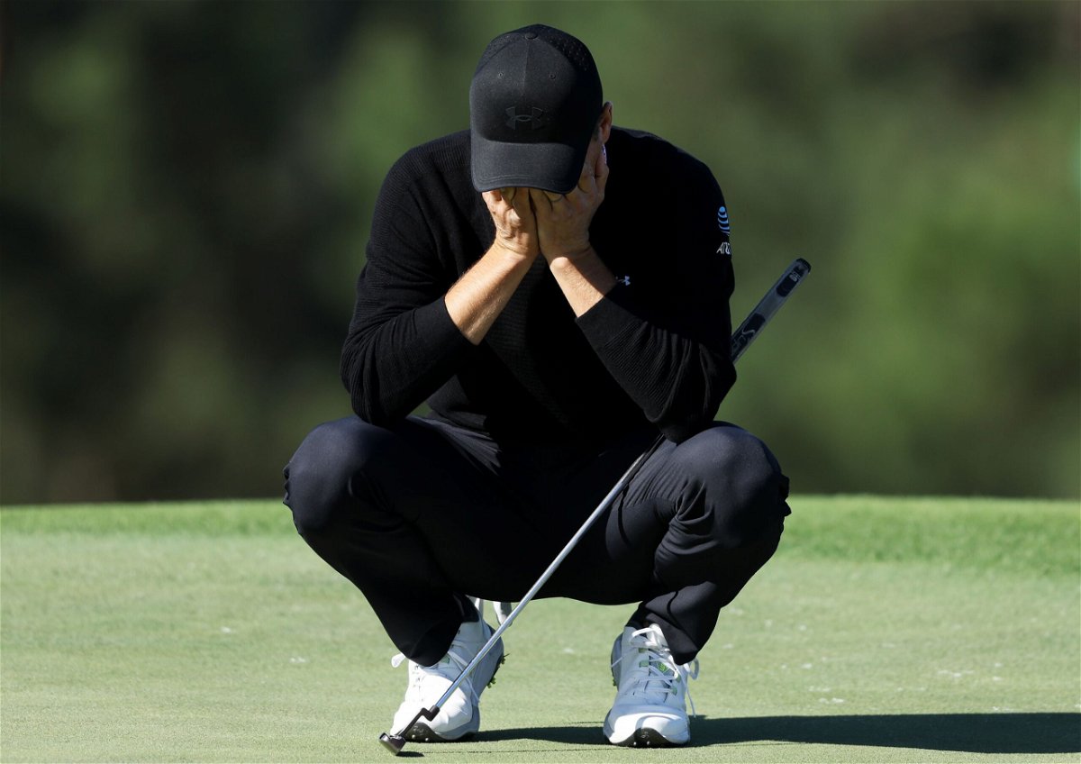 <i>Ashley Landis/AP via CNN Newsource</i><br/>Jason Day shields himself from windswept sand at the 18th hole.