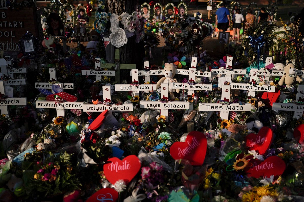 <i>Jae C. Hong/AP via CNN Newsource</i><br/>Flowers are piled around crosses with the names of the victims killed in a school shooting as people visit a memorial at Robb Elementary School to pay their respects May 31