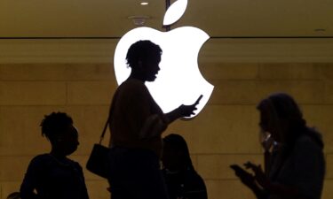 A woman uses an iPhone at the Apple store at Grand Central Terminal in New York City. Apple is widely expected to announce a partnership with ChatGPT maker OpenAI.